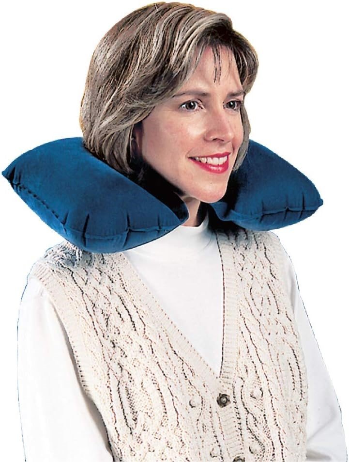 A woman using a compressible travel pillow for neck support. The pillow is compact and easily fits into her carry-on luggage